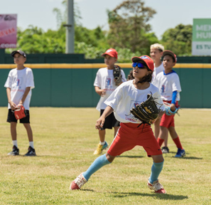 Niños practicando béisbol en un campo restaurado